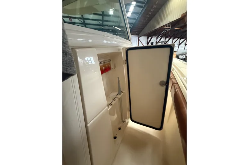  Yacht Photos Pics 2016 Scout 350 LXF boat storage compartment with open door in a marina setting.