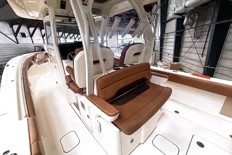  Yacht Photos Pics 2016 Scout 350 LXF boat interior with brown seating and white deck in a warehouse.