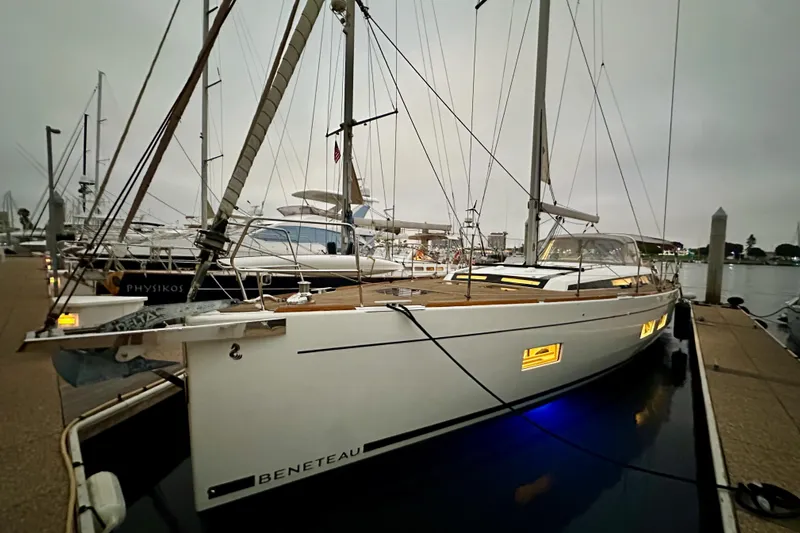 Champagne Yacht Photos Pics 2021 Beneteau Oceanis 55.1 yacht docked at marina, illuminated windows, evening setting.