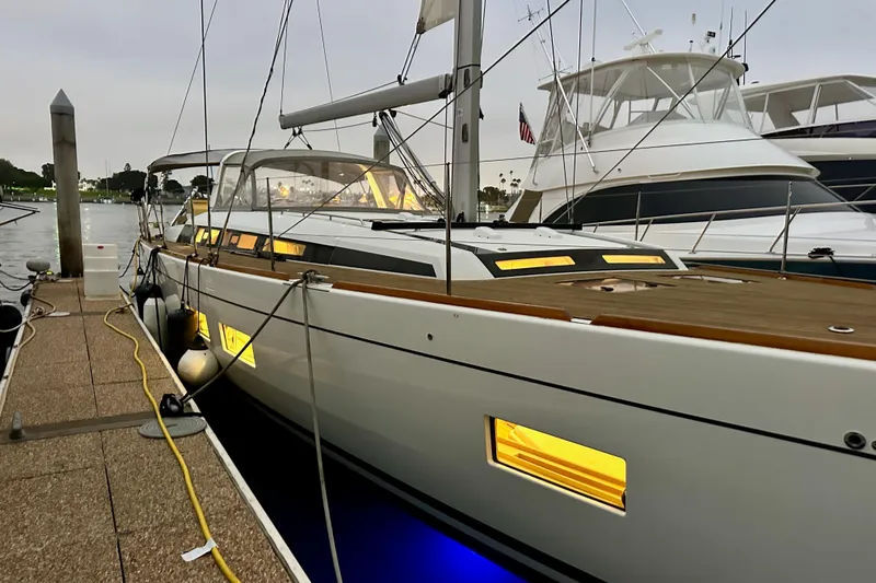 Champagne Yacht Photos Pics 2021 Beneteau Oceanis 55.1 yacht docked, illuminated windows, evening setting.