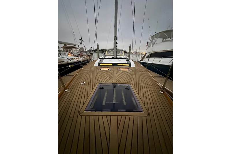 Champagne Yacht Photos Pics 2021 Beneteau Oceanis 55.1 yacht deck with sleek wooden finish, docked at marina.