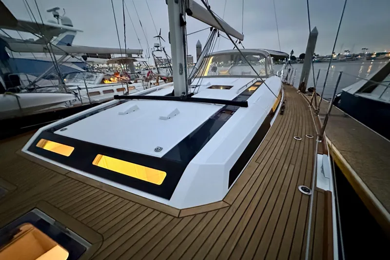 Champagne Yacht Photos Pics 2021 Beneteau Oceanis 55.1 yacht with illuminated deck at marina during dusk.