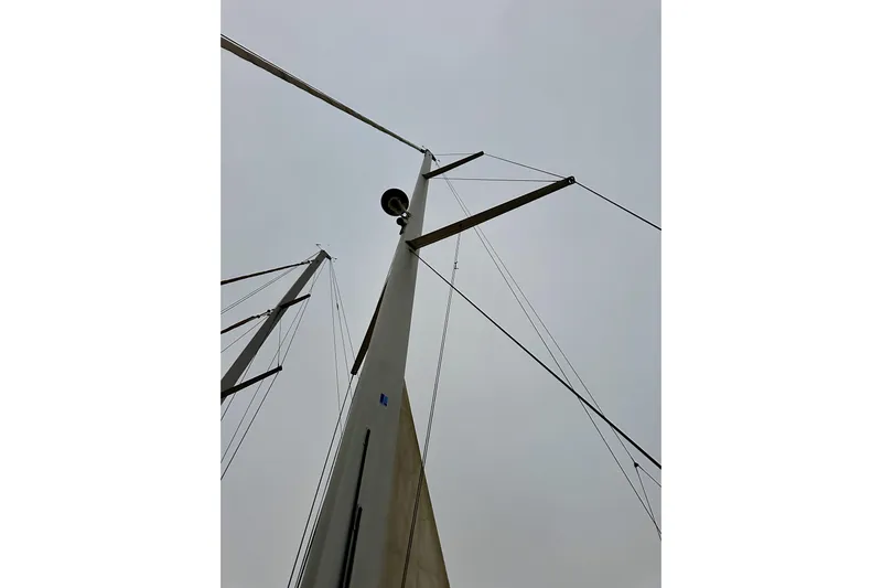 Champagne Yacht Photos Pics Mast of 2021 Beneteau Oceanis 55.1 sailboat against cloudy sky.