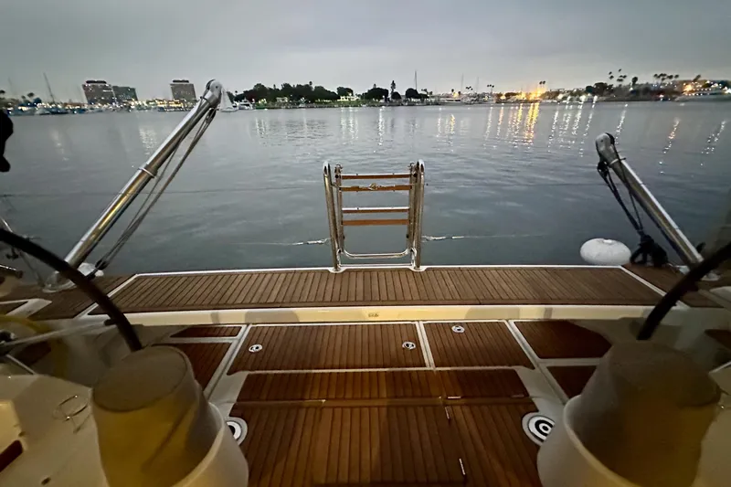 Champagne Yacht Photos Pics Beneteau Oceanis 55.1 yacht deck overlooking calm waters at dusk, 2021 model.