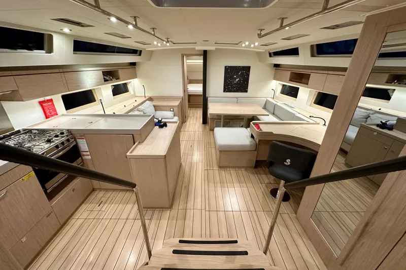 Champagne Yacht Photos Pics Luxurious interior of 2021 Beneteau Oceanis 55.1 yacht with modern kitchen and seating area.