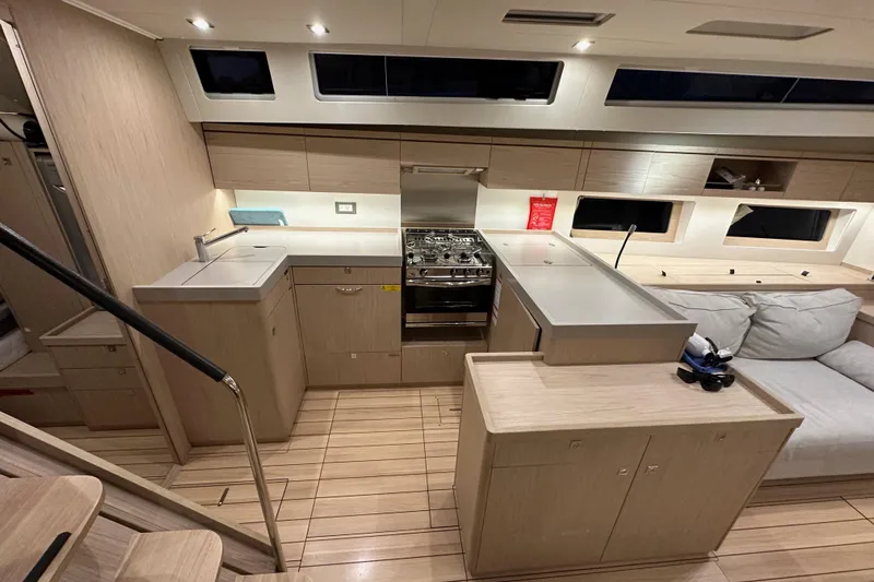 Champagne Yacht Photos Pics Modern interior of 2021 Beneteau Oceanis 55.1 yacht with sleek kitchen and seating area.