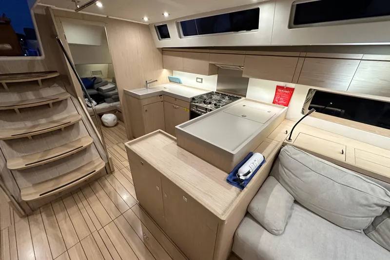 Champagne Yacht Photos Pics Luxurious interior of 2021 Beneteau Oceanis 55.1 yacht with modern kitchen and seating area.