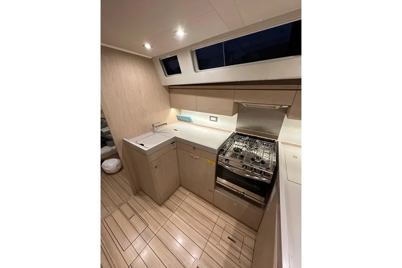 Champagne Yacht Photos Pics Modern kitchen interior of 2021 Beneteau Oceanis 55.1 yacht with sleek design and appliances.