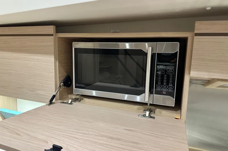 Champagne Yacht Photos Pics Built-in microwave in 2021 Beneteau Oceanis 55.1 yacht kitchen cabinet.