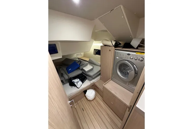 Champagne Yacht Photos Pics Interior of 2021 Beneteau Oceanis 55.1 yacht with washing machine and storage area.