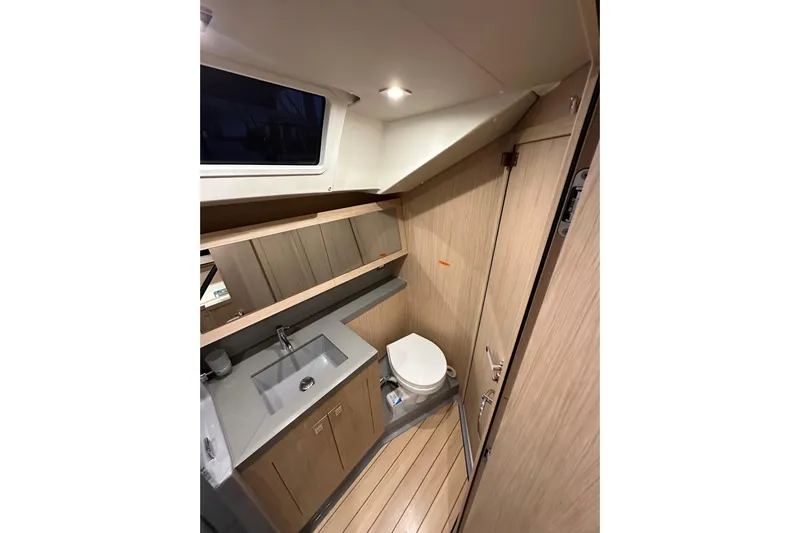 Champagne Yacht Photos Pics Interior of 2021 Beneteau Oceanis 55.1 yacht bathroom with modern fixtures and wood finish.