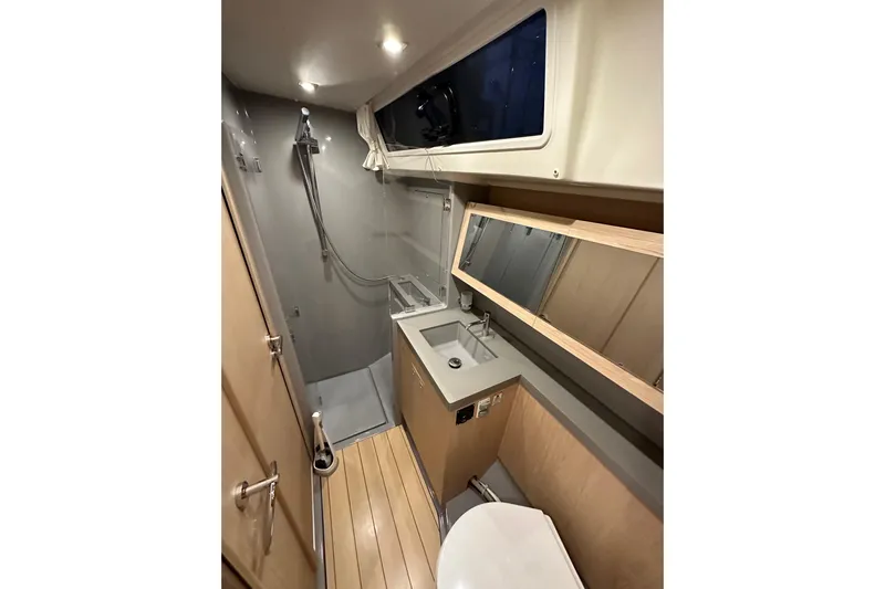Champagne Yacht Photos Pics Modern bathroom in 2021 Beneteau Oceanis 55.1 yacht with shower, sink, and toilet.