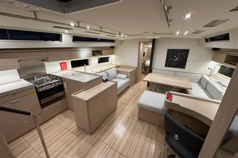 Champagne Yacht Photos Pics Luxurious interior of 2021 Beneteau Oceanis 55.1 yacht with modern kitchen and seating area.
