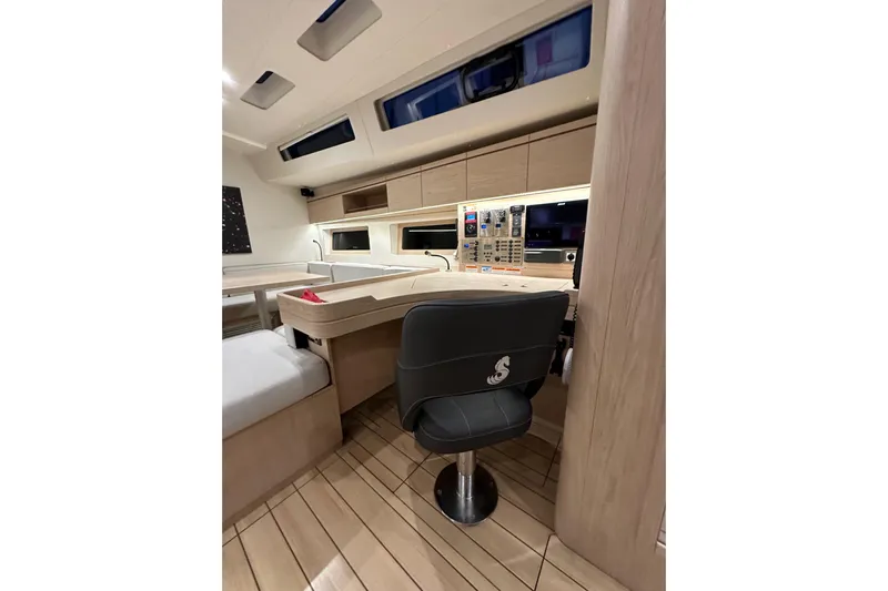 Champagne Yacht Photos Pics Interior of 2021 Beneteau Oceanis 55.1 yacht, featuring modern navigation station and seating.