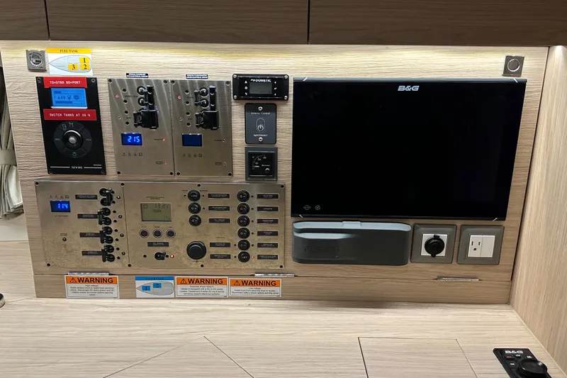 Champagne Yacht Photos Pics Control panel of a 2021 Beneteau Oceanis 55.1 yacht with navigation and electrical systems.