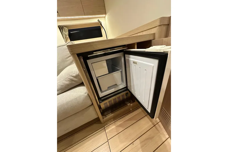 Champagne Yacht Photos Pics Compact refrigerator in 2021 Beneteau Oceanis 55.1 yacht interior, open door view.