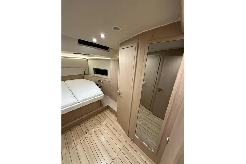 Champagne Yacht Photos Pics Luxurious interior of 2021 Beneteau Oceanis 55.1 yacht cabin with modern wood finish.