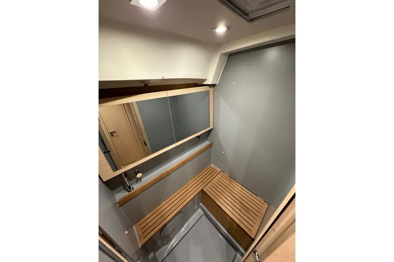Champagne Yacht Photos Pics Interior of 2021 Beneteau Oceanis 55.1 yacht bathroom with wooden accents and mirror.