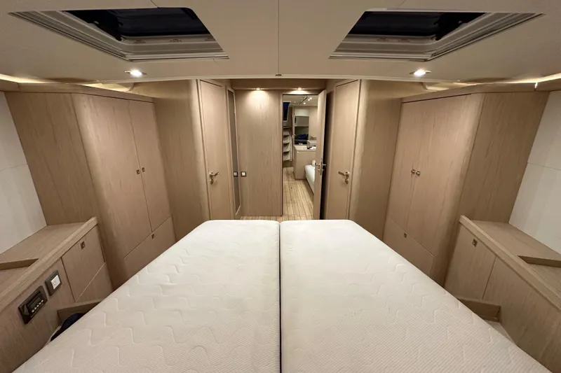Champagne Yacht Photos Pics Luxurious interior of 2021 Beneteau Oceanis 55.1 yacht cabin with modern wood finish.
