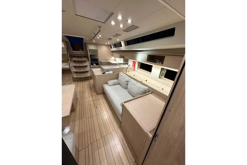 Champagne Yacht Photos Pics Luxurious interior of 2021 Beneteau Oceanis 55.1 yacht with modern furnishings and wooden flooring.