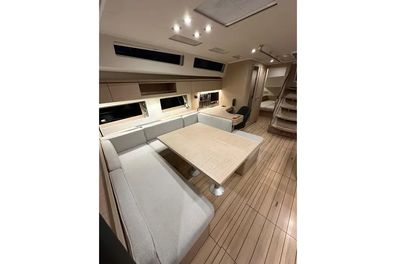 Champagne Yacht Photos Pics Interior of 2021 Beneteau Oceanis 55.1 yacht, featuring modern dining area and wooden flooring.