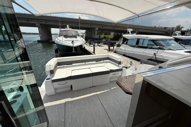  Yacht Photos Pics 2022 Cruisers Yachts 50 Cantius, docked with spacious seating area under canopy.