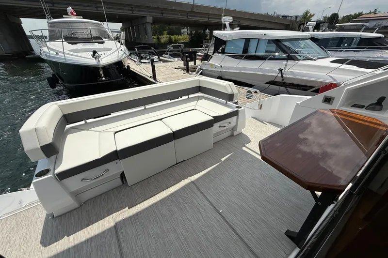  Yacht Photos Pics 2022 Cruisers Yachts 50 Cantius deck with seating and table, docked at marina.