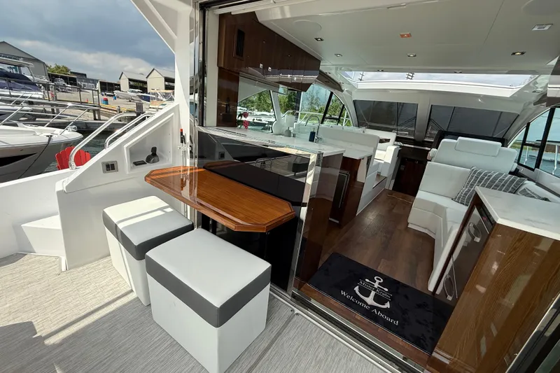  Yacht Photos Pics 2022 Cruisers Yachts 50 Cantius interior with modern seating and sleek design at a marina.