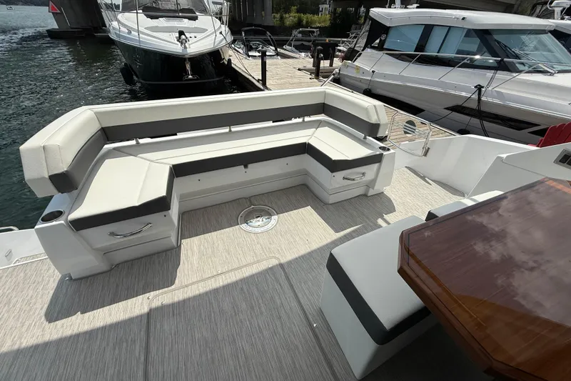  Yacht Photos Pics Luxurious 2022 Cruisers Yachts 50 Cantius with spacious outdoor seating and elegant wooden table.