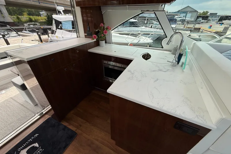  Yacht Photos Pics Luxurious 2022 Cruisers Yachts 50 Cantius interior with modern kitchen and marina view.
