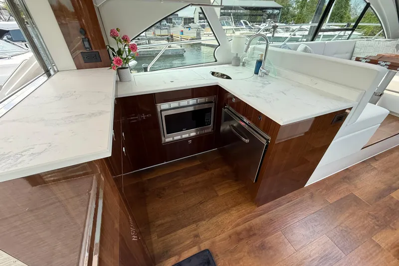  Yacht Photos Pics Luxurious 2022 Cruisers Yachts 50 Cantius kitchen with modern appliances and elegant wood flooring.