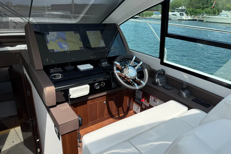  Yacht Photos Pics Interior helm of 2022 Cruisers Yachts 50 Cantius with navigation screens and steering wheel.