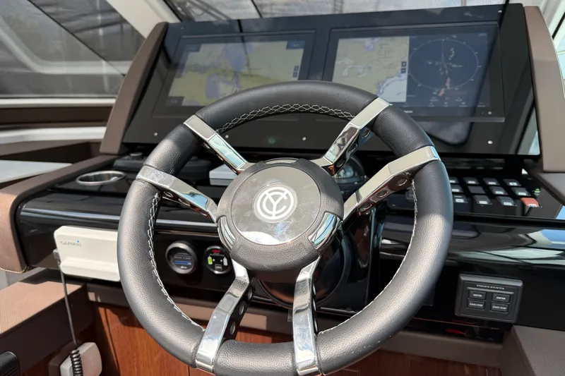  Yacht Photos Pics Steering wheel and dashboard of 2022 Cruisers Yachts 50 Cantius with navigation screens.