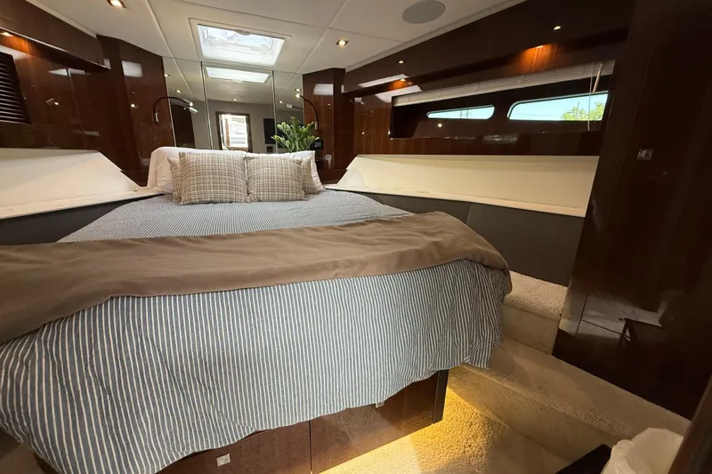  Yacht Photos Pics Luxurious bedroom interior of 2022 Cruisers Yachts 50 Cantius with elegant bedding and wood finishes.