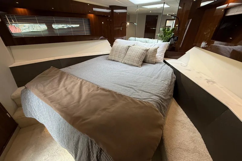  Yacht Photos Pics Luxurious bedroom interior of 2022 Cruisers Yachts 50 Cantius with elegant bedding and wood accents.