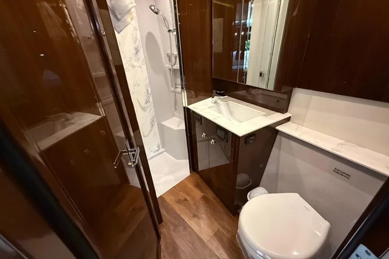  Yacht Photos Pics Luxurious bathroom in 2022 Cruisers Yachts 50 Cantius with modern fixtures and elegant wood finishes.