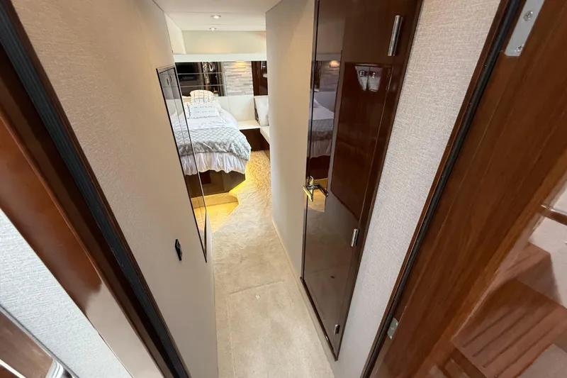  Yacht Photos Pics Luxurious interior hallway of 2022 Cruisers Yachts 50 Cantius, leading to a cozy bedroom.