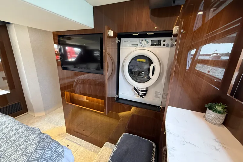  Yacht Photos Pics 2022 Cruisers Yachts 50 Cantius interior with washer, TV, and elegant wood finish.