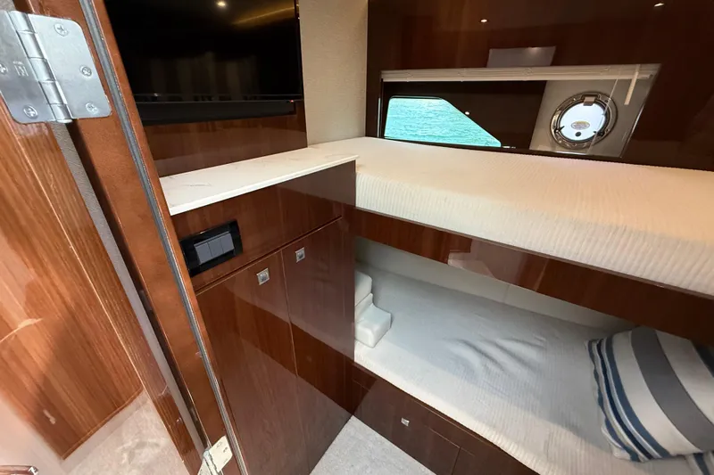  Yacht Photos Pics 2022 Cruisers Yachts 50 Cantius cabin with bunk beds and porthole view.