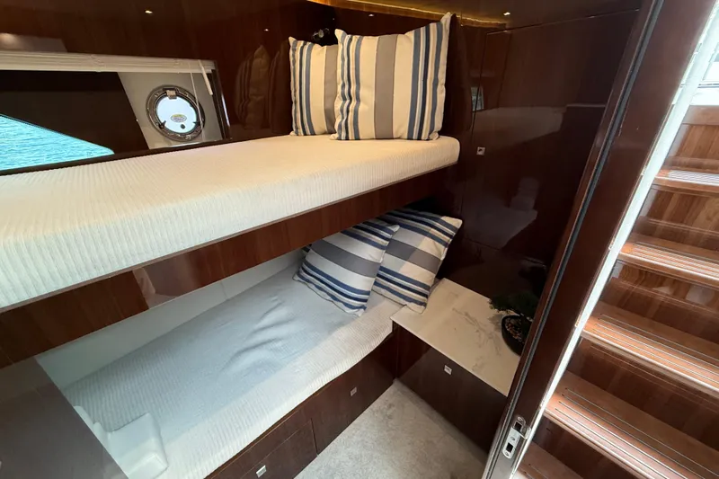  Yacht Photos Pics Luxurious 2022 Cruisers Yachts 50 Cantius cabin with bunk beds and striped pillows.