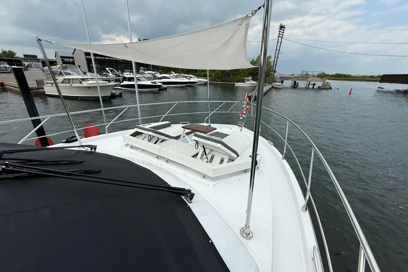  Yacht Photos Pics 2022 Cruisers Yachts 50 Cantius on water, featuring spacious deck and seating area.