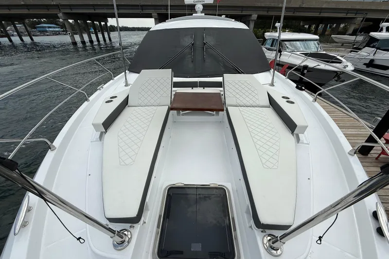  Yacht Photos Pics 2022 Cruisers Yachts 50 Cantius deck with luxurious seating and table, docked by the water.