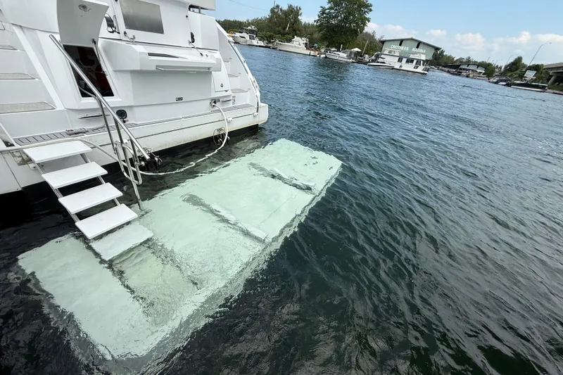  Yacht Photos Pics 2022 Cruisers Yachts 50 Cantius with submerged swim platform in marina setting.