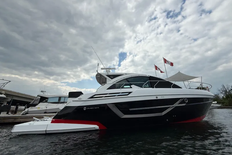 Yacht Photos Pics 2022 Cruisers Yachts 50 Cantius docked under cloudy sky with flags.