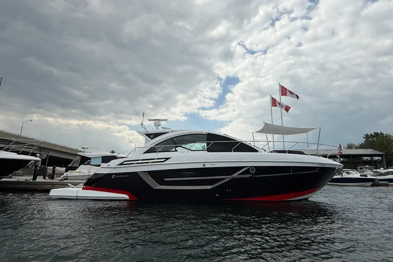  Yacht Photos Pics 2022 Cruisers Yachts 50 Cantius docked under cloudy sky with flags.