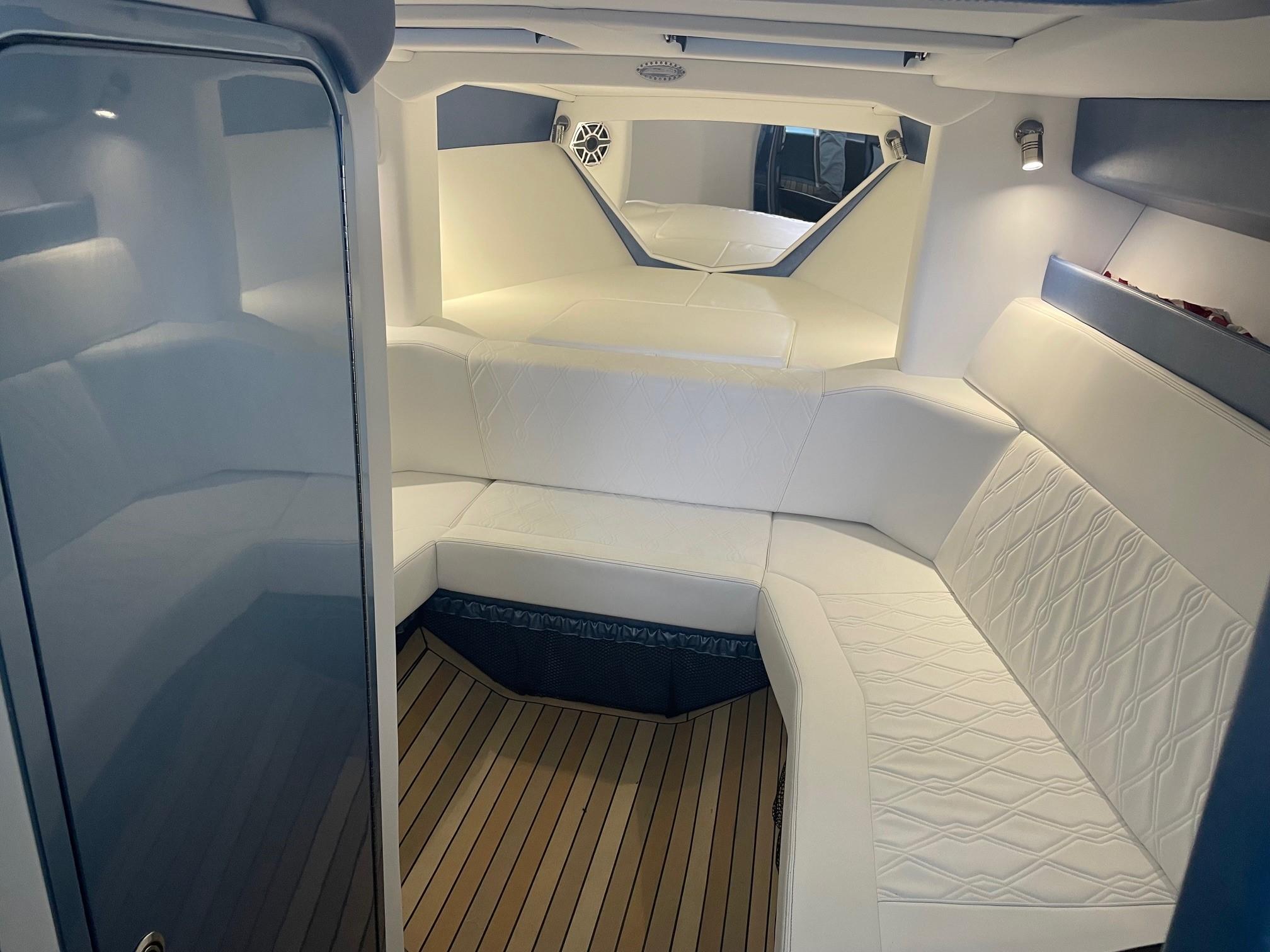 Luxurious interior of 2025 Nor-Tech 420 Monte Carlo with white seating and wood flooring.