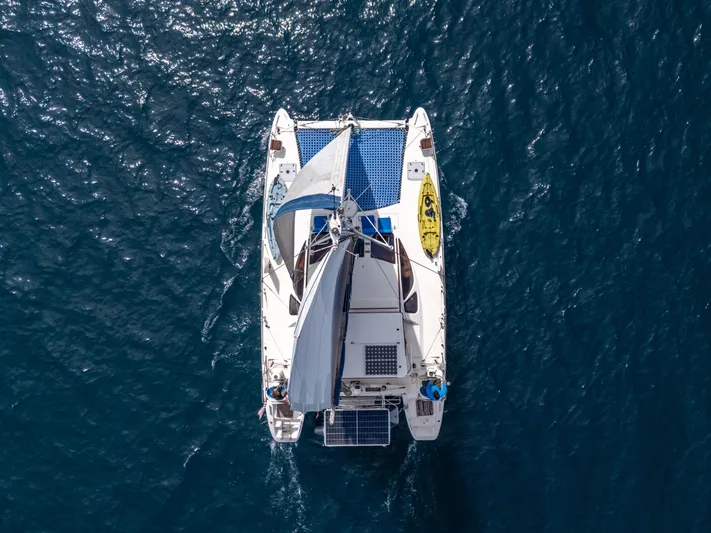 Nina May Yacht Photos Pics Aerial view of 2001 Catana 431 catamaran sailing on blue ocean waters.