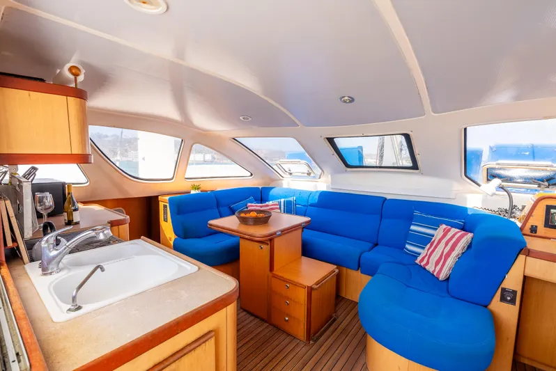 Nina May Yacht Photos Pics Interior of 2001 Catana 431 yacht with blue seating and wooden accents.