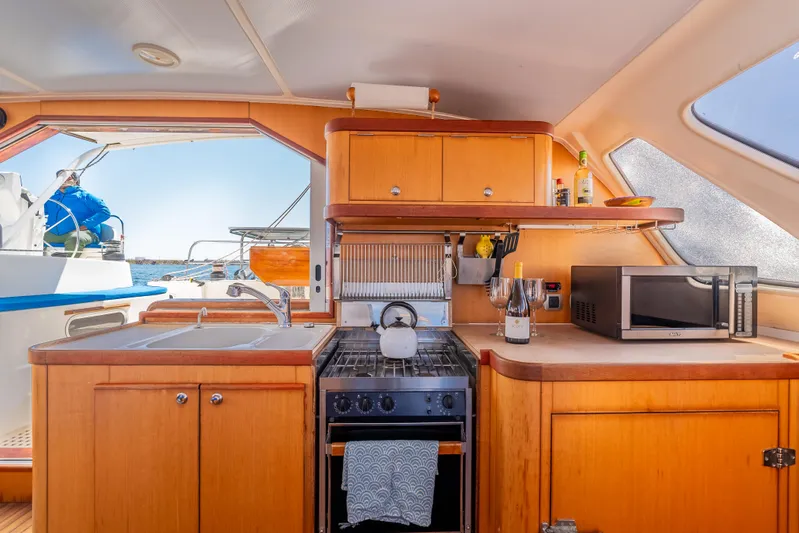 Nina May Yacht Photos Pics Catana 431 yacht kitchen interior, featuring stove, sink, and microwave, 2001 model.