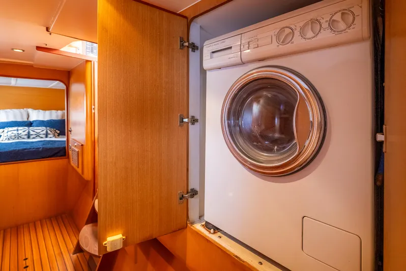 Nina May Yacht Photos Pics Washing machine in 2001 Catana 431 yacht interior, wooden cabinetry, cozy cabin view.